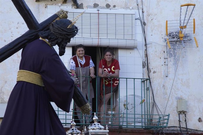 Dos señoras asomadas a su balcón ante el paso del Señor del Gran Poder durante el traslado a la Parroquia de las Candelarias 