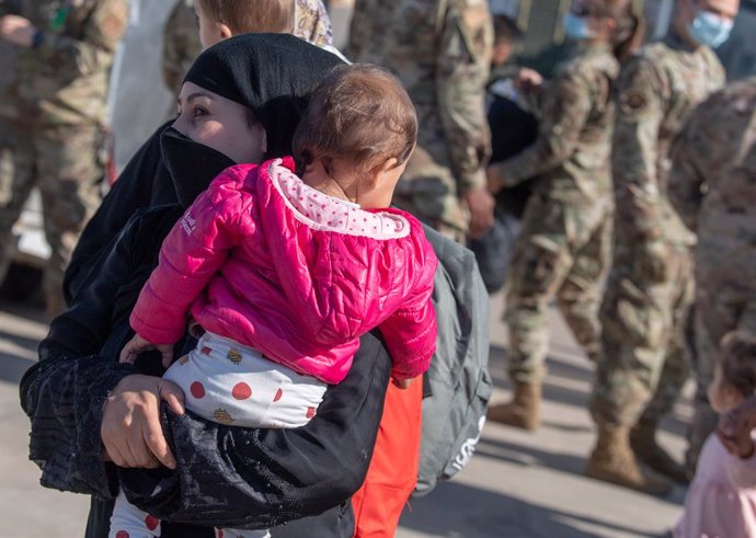 09 October 2021, Rhineland-Palatinate, Ramstein: An Afghan woman and her child go to a collection point before their departure for the US. The US is resuming flights from Ramstein for people who are expected to be flown out of the base to USA over the n