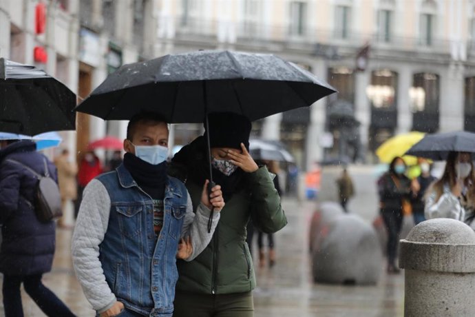 Archivo - Transeúntes pasean protegidos con paraguas por el centro de la capital, en Madrid, (España), a 27 de noviembre de 2020. El año hidrológico, que comenzó el 1 de octubre, acumula hasta el 24 de noviembre un 16 por ciento menos lluvias de lo norm