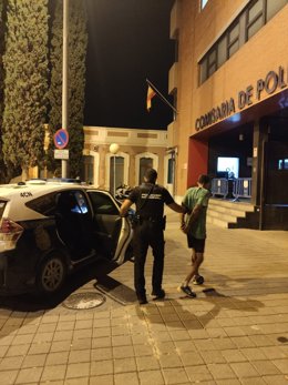 Imagen del detenido, custodiado por la Policía Nacional, en su llegada a la Comisaría