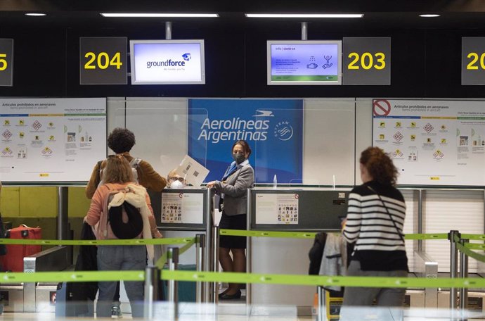 Archivo - Varias personas frente a un mostrador de Aerolíneas Argentinas, en la Terminal T1 del Aeropuerto Madrid - Barajas Adolfo Suárez, en Madrid (España), a 30 de marzo de 2021.