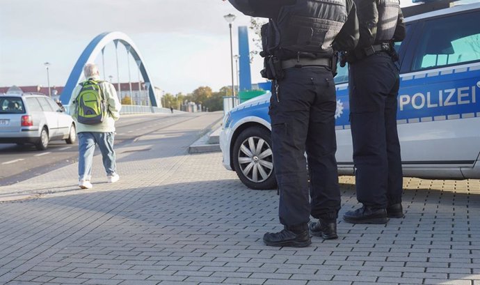 23 October 2021, Brandenburg, Frankfurt: Federal police officers stand at the border bridge connecting Germany with Poland. The number of refugees arriving in Brandenburg via Belarus and Poland is increasing. Photo: Jrg Carstensen/dpa