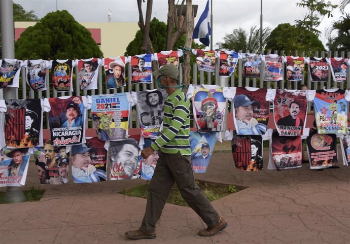 Un hombre pasea por las calles de Managua frente a un puesto de venta de camisetas con la imagen del presidente, Daniel Ortega