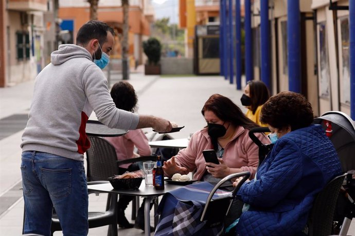 Archivo - Un camarero atiende a dos clientas en la terraza de un bar, en Alcantarilla, Murcia