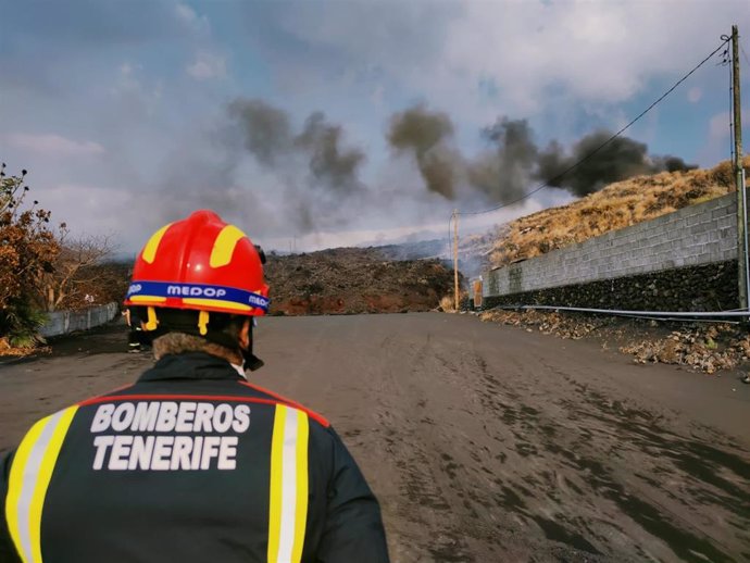 Un profesional del Consorcio de Bomberos de Tenerife vigila el avance de la colada sur en la isla de La Palma