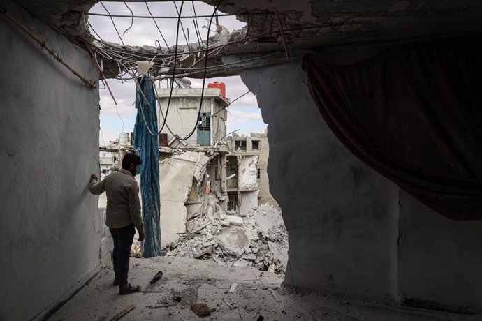 20 October 2021, Syria, Ariha: Khaled Ibrahim, 58, and his children clean the rubble from their house in Ariha, which was destroyed after it was hit earlier in the day in a missile shelling, allegedly carried out by Syrian government forces. Several peo