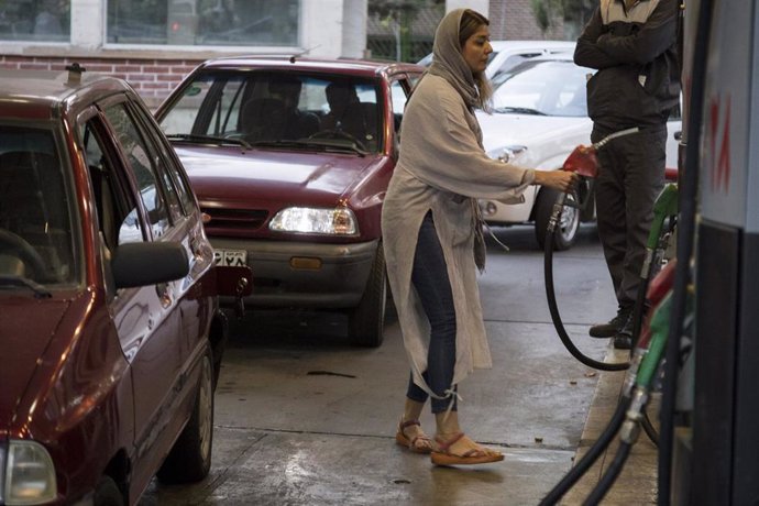 Archivo - Una mujer iraní reposta su coche en Teherán 