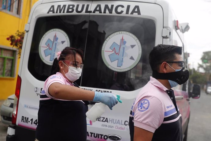 Archivo - Trabajadores sanitarios junto a una ambulancia en México
