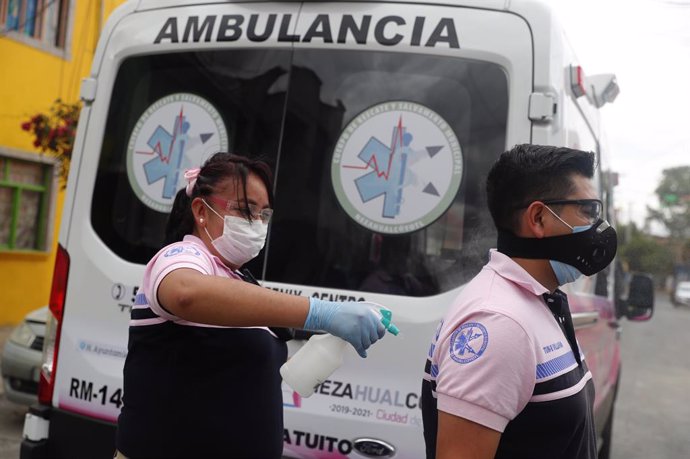 Archivo - Trabajadores sanitarios junto a una ambulancia en México