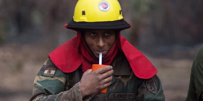 Archivo - 26 August 2019, Bolivia, San Juan: A firefighter drinks water during his mission in the Amazon region. In Brazil, the most violent fires have been raging for years, but numerous fires have also broken out in neighbouring countries Peru, Bolivi