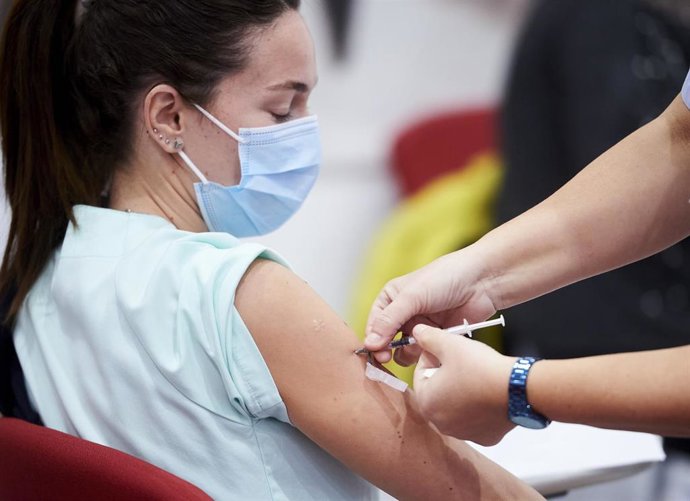 Archivo - Un trabajadora sanitaria inyecta la segunda dosis de la vacuna de Pfizer.- Archivo