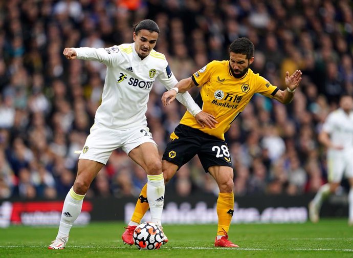 23 October 2021, United Kingdom, Leeds: Leeds United's Pascal Struijk (L) and Wolverhampton Wanderers' Joao Moutinho battle for the ball during the English Premier League soccer match between Leeds United and Wolverhampton Wanderers at Elland Road Stadi
