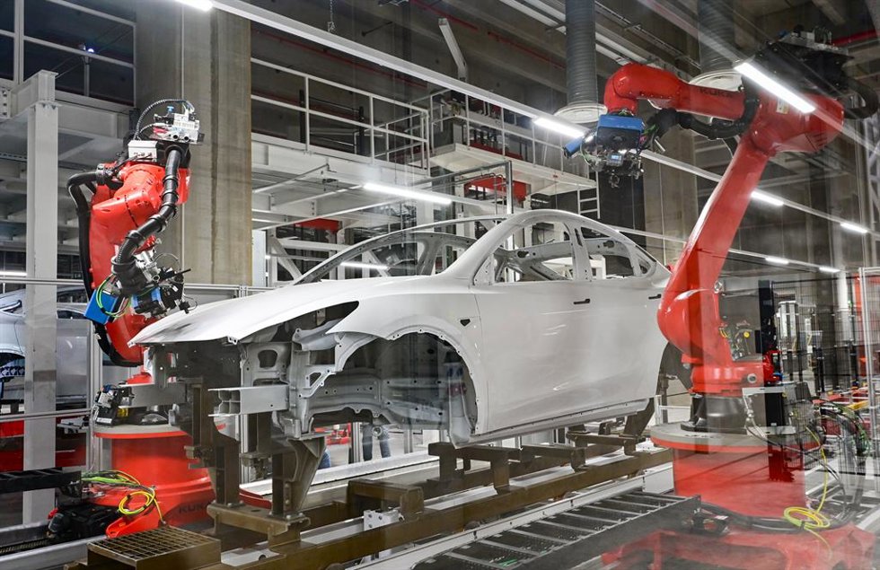 09 October 2021, Brandenburg, Gruenheide: Robotic arms work on a Tesla Model Y at a production hall of the Tesla Gigafactory during at a production hall of the Tesla Gigafactory during an open day. Thousands of visitors are expected to attend the open d