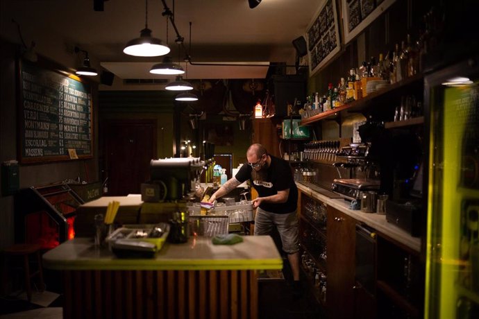 Un camarero en el interior de un bar en una calle céntrica de Barcelona. Foto de archivo.