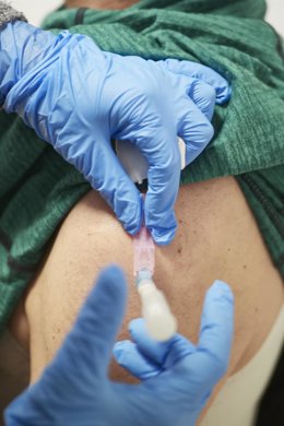 Archivo - Una sanitaria vacuna contra el Covid-19 a una persona.