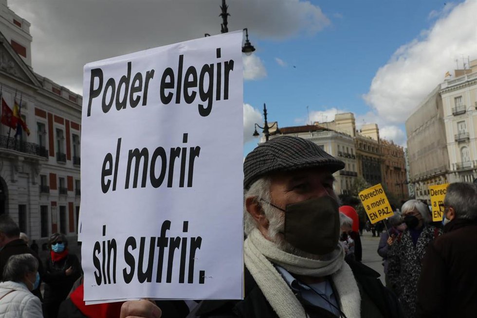 Archivo - Un hombre con un cartel en el que se lee: `Poder elegir el morir sin sufrir durante una concentración de Derecho a Morir Dignamente en la Puerta del Sol, en Madrid (España), a 18 de marzo de 2021.
