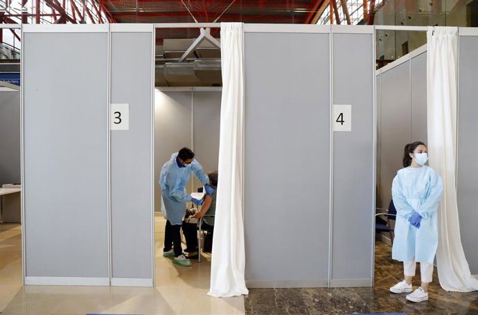 Archivo - Varias personas asisten a la vacunación masima en el Palacio de Ferias y Congresos de Málaga, foto de archivo