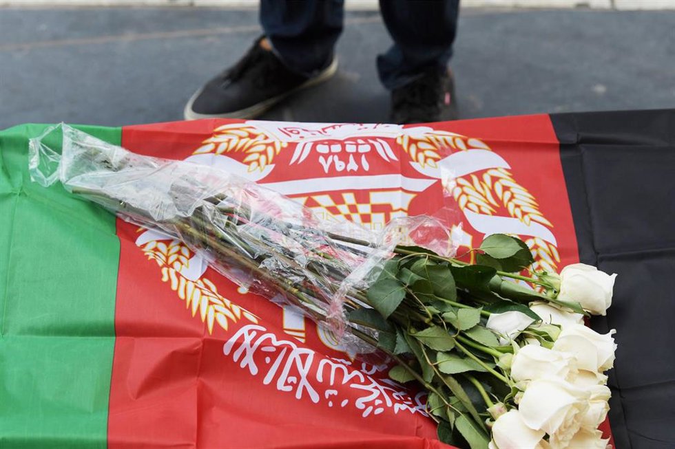 Flores sobre una bandera de Afganistán durante una manifestación contra los ataques con drones en el país asiático