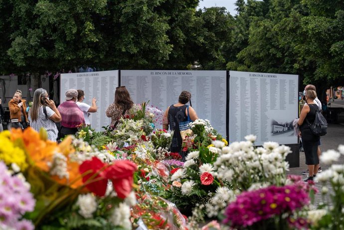 Vecinos se acercan a la zona donde se encuentra un altar instalado para rendir homenaje a las personas enterradas en cementerios afectados por la lava