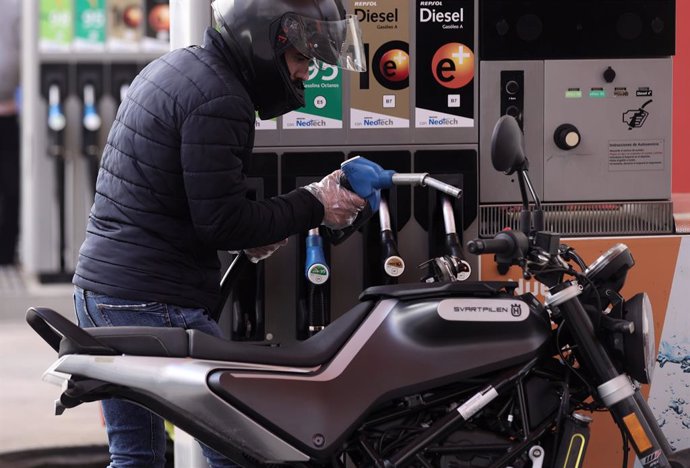 Un hombre inyecta carburante en una moto, a 28 de octubre de 2021, en Madrid (España)
