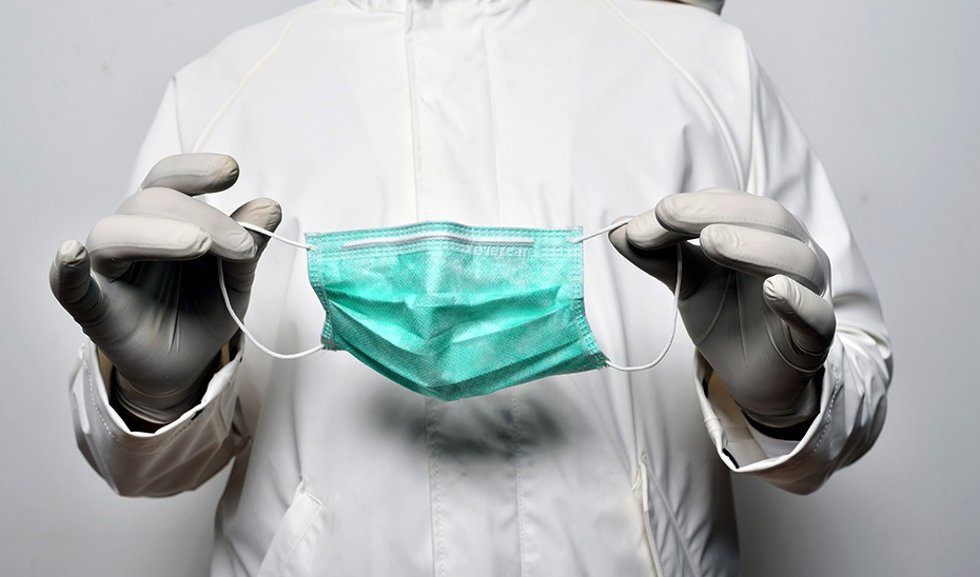 Archivo - Un médico sostiene una mascarilla en sus manos en una imagen de archivo 