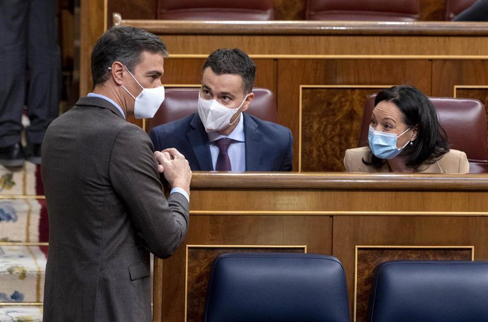 El presidente del Gobierno, Pedro Sánchez (i), conversa con el portavoz del Grupo Parlamentario Socialista en el Congreso de los Diputados, Héctor Gómez