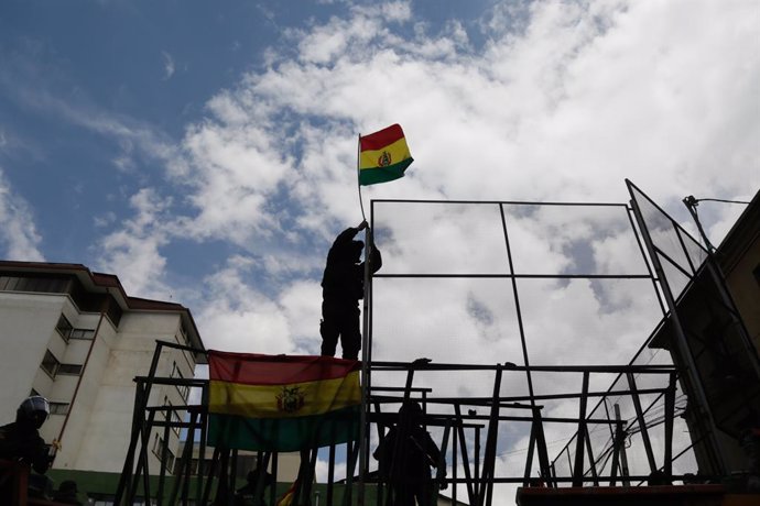 Archivo - 09 November 2019, Bolivia, La Paz: A group of police officers of the UTOP (Technical Unit for Police Operations), raise the Bolivian flag during a protest against Bolivian  President Evo Morales. Various police units in at least four regions r