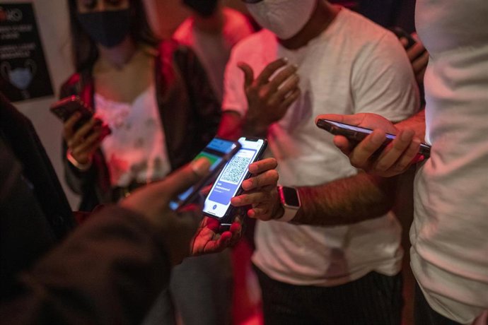 Una persona muestra un código QR para entrar a un local.