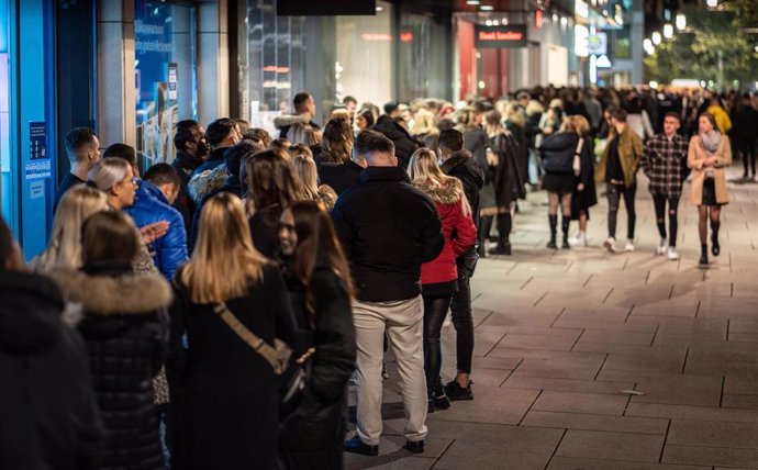 23 October 2021, Hessen, Frankfurt_Main: People wait in a long queue in front of the entrance to the club Gibson in the city centre.