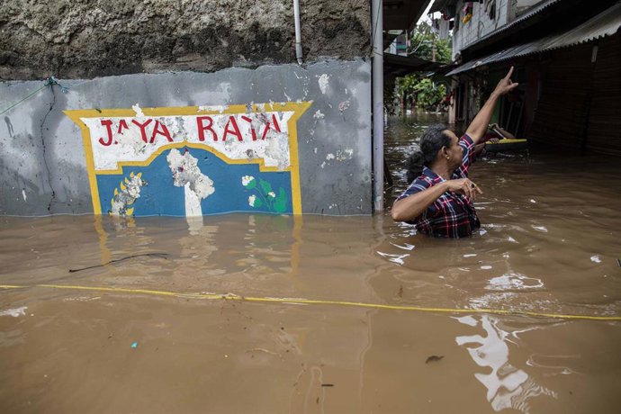 Archivo - Un hombre en un barrio inundado tras fuertes lluvias en la capital de Indonesia, Jakarta  