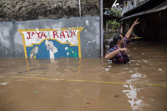 Archivo - 20 February 2021, Indonesia, Jakarta: A man wades through a flooded neighbourhood following heavy rains. Floods inundated parts of the Indonesian capital and its surrounding towns on Saturday following heavy rain overnight, displacing thousand