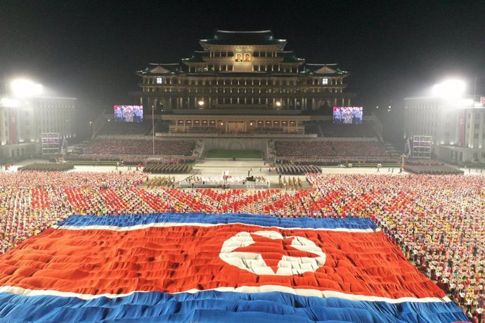 Archivo - 09 September 2021, North Korea, Pyongyang: A picture provided by the North Korean state news agency (KCNA) on 09 September 2021, shows North Korean soldiers unfolding a North Korean flag during a military parade at Kim Il-sung Square to celebr