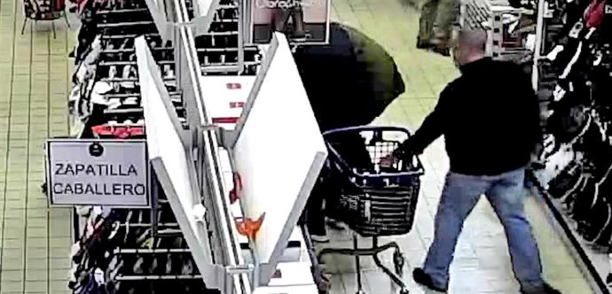 Imagen de una cámara de seguridad en la que el detenido sustrae las pertenencias de una mujer de su carro de la compra