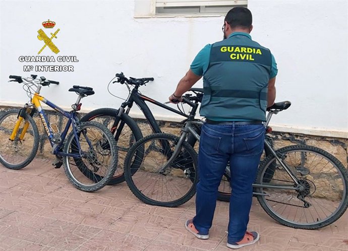 Un agente de la Guardia Civil muestra las bicicletas recuperadas