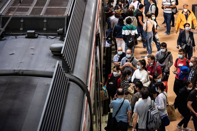 Varios pasajeros esperan a subir a un tren en la estación de Atocha - Cercanías.