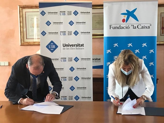 El rector de la UIB, Jaume Carot, y la directora territorial de CaixaBank en Baleares, María Cruz Rivera, firman los convenios de colaboración en materia de acción social.