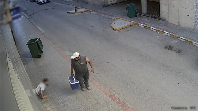 El detenido, en la imagen durante uno de los robos sale de un establecimiento arrastrándose por el suelo