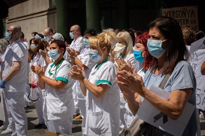 Archivo - Varias trabajadoras protegidas con mascarilla se reúnen a las puertas del Hospital Clínic de Barcelona.