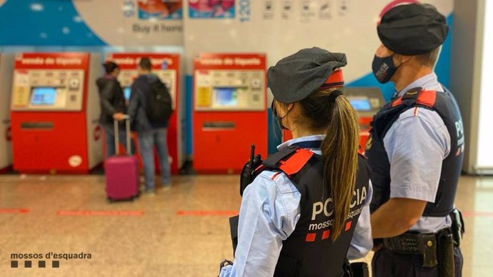 Dos agents dels Mossos d'Esquadra vigilen en una estació de metro de Barcelona.