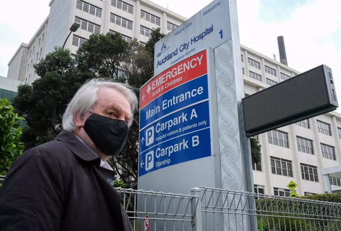 Archivo - Una persona camina frente a un hospital en Nueva Zelanda