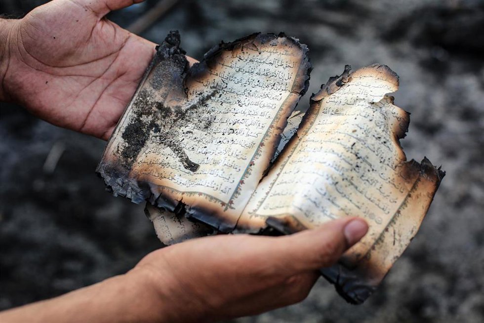 Un corán ardiendo tras los enfrentamientos entre grupos proiraníes y la Policía en Bagdad 