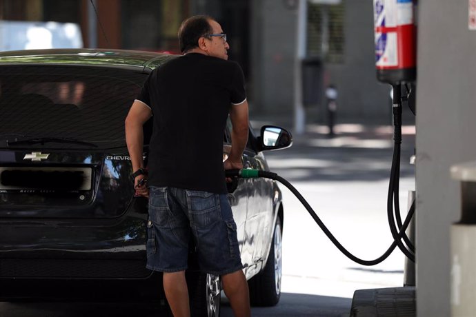 Archivo - Un hombre pone gasolina en su coche en una gasolinera de Madrid.
