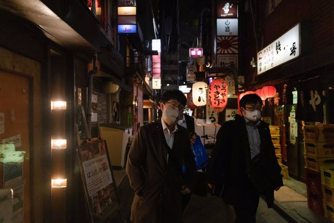 November 4, 2021, Tokyo, Japan: Businessmen wearing facemasks as a precaution against the spread of covid-19 seen walking through a side alley in Shimbashi district.
