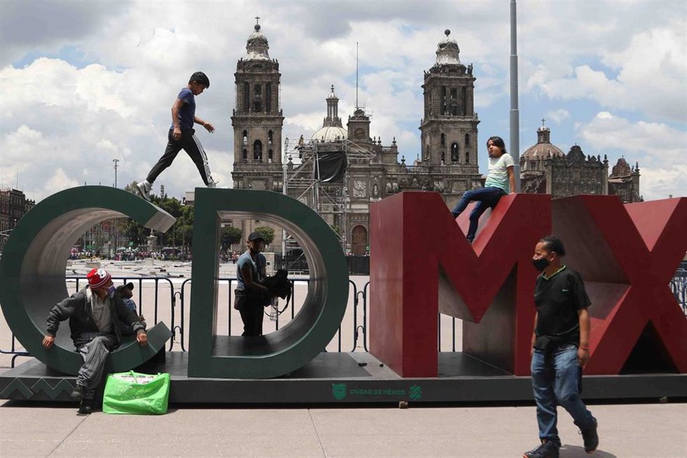 Archivo - Ciudadanos pasean frente a un cartel con el nombre de la capital mexicana en Ciudad de México