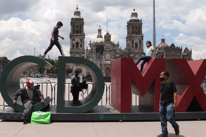 Archivo - Ciudadanos pasean frente a un cartel con el nombre de la capital mexicana en Ciudad de México