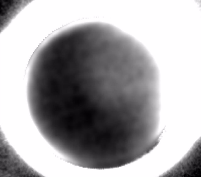 Caronte ilumina Plutón: La imagen muestra el lado oscuro de Plutón rodeado por un anillo brillante de luz solar disperso por la neblina en su atmósfera.