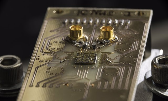 Archivo - Se muestra un chip semiconductor de procesador cuántico conectado a una placa de circuito.