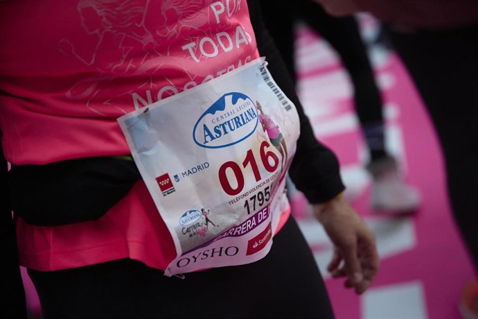 Una las corredoras de la XVIII Carrera de la Mujer lleva un dorsal con el número 016, teléfono de asistencia a víctimas de la violencia de género.