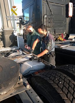 Dos agentes inspeccionan uno de los vehículos