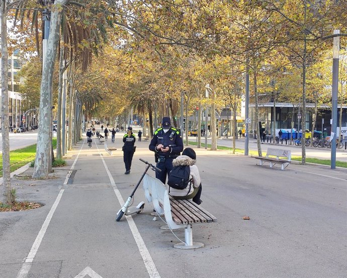 Un agent de la Gurdia Urbana multa una usuria de patinet elctric a Barcelona